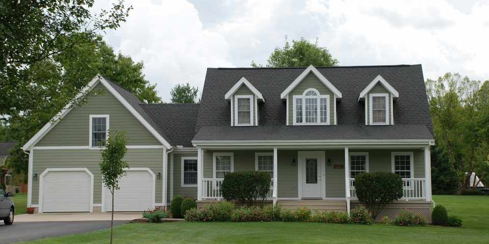 White and gray home exterior near a green grass field